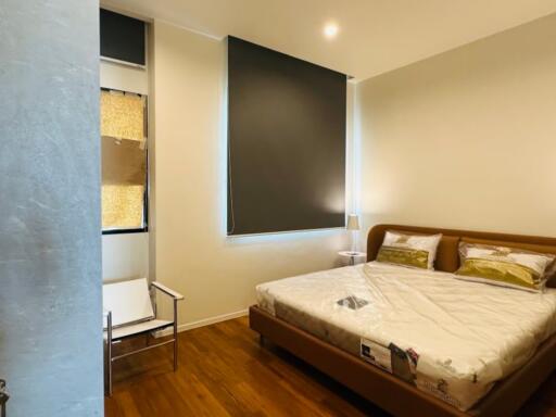 Modern furnished bedroom with a large bed and windows