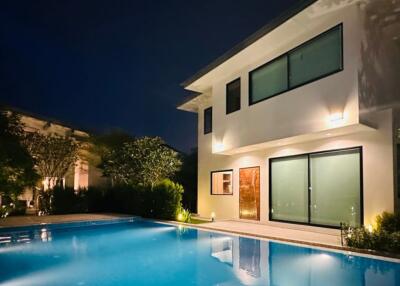 Exterior view of a house with a pool at night