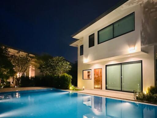 Exterior view of a house with a pool at night