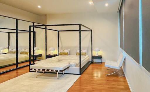 Modern bedroom with a four-poster bed and large mirror