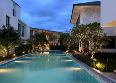 Modern residential buildings around a swimming pool at dusk