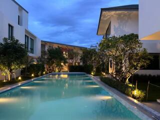 Modern residential buildings around a swimming pool at dusk