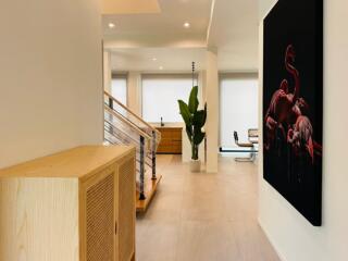 Modern hallway with artwork and view of living area