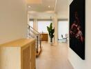 Modern hallway with artwork and view of living area