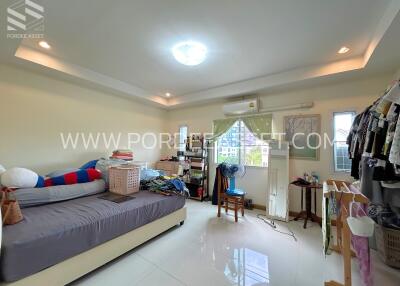 Spacious bedroom with natural light and clutter