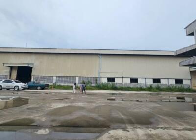 Exterior view of a large warehouse with vehicles