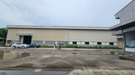 Exterior view of a large warehouse with vehicles