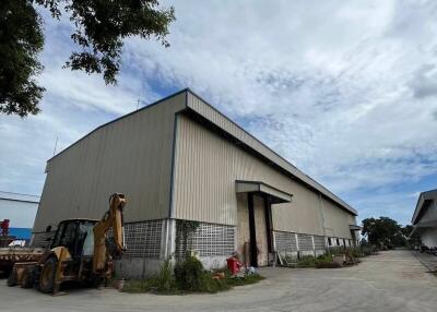 Exterior view of a warehouse building with adjacent equipment