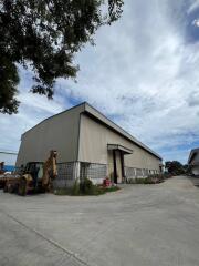 Exterior view of a warehouse building with adjacent equipment