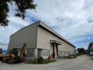 Exterior view of a warehouse building with adjacent equipment