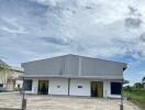 Exterior view of a large industrial building with blue sky.