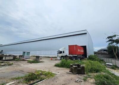 Exterior of a warehouse with a truck and shipping container