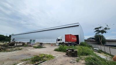 Exterior of a warehouse with a truck and shipping container