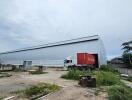 Exterior of a warehouse with a truck and shipping container