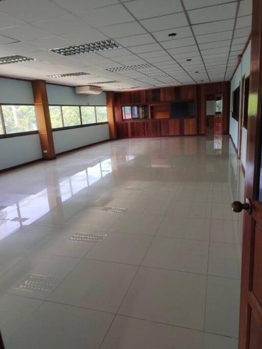 Spacious empty room with large windows and tiled flooring