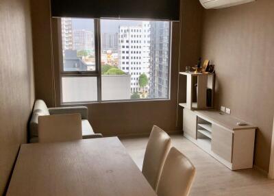 Modern living room with dining table, sofa, air conditioner, and city view window