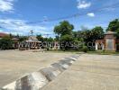 Outdoor area with a paved road, greenery, and decorative structures