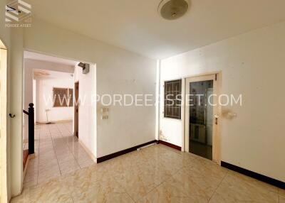 Main living area with tile flooring and a door to another room