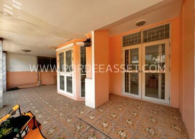 Covered outdoor patio with tiled flooring and large glass doors and windows