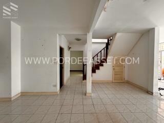 Spacious living area with tile flooring and staircase