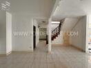 Spacious living area with tile flooring and staircase