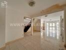 Spacious interior area with tiled floor and staircase