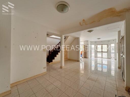 Spacious interior area with tiled floor and staircase