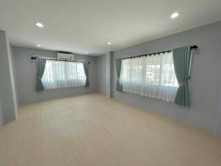 Spacious and bright main living area with large windows and curtains