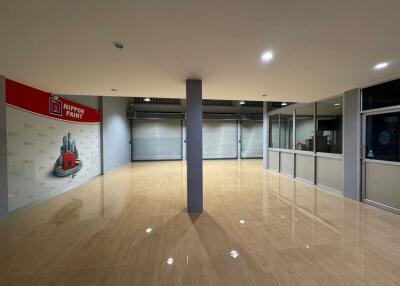 Empty commercial space with glossy flooring and roller shutter doors