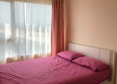 Bedroom with pink bedding and large window