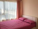 Bedroom with pink bedding and large window