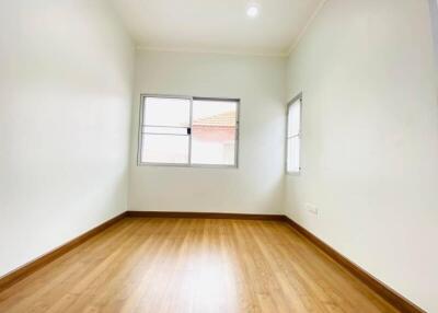 Empty bedroom with wooden floors and windows