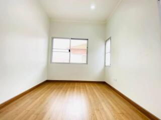 Empty bedroom with wooden floors and windows