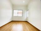 Empty bedroom with wooden floors and windows