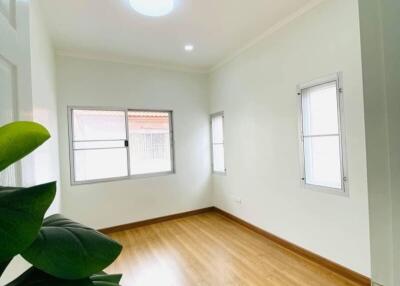 bright empty bedroom with wooden floor and windows