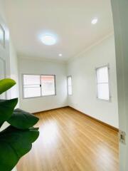 bright empty bedroom with wooden floor and windows