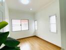 bright empty bedroom with wooden floor and windows