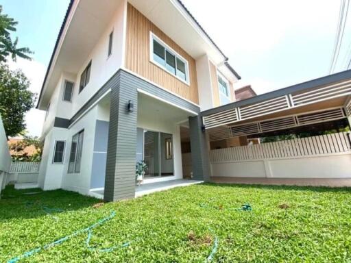 Exterior view of a contemporary two-story house with a well-maintained lawn.