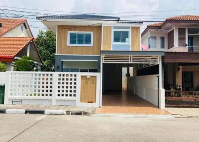 Exterior view of a modern two-story house with a carport