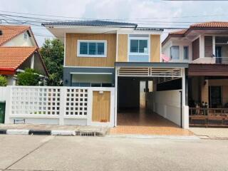 Exterior view of a modern two-story house with a carport