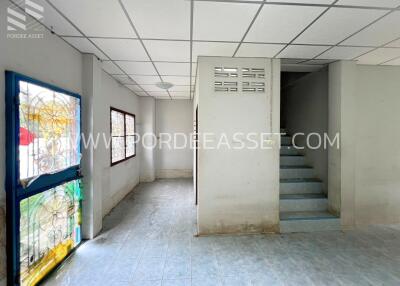 Main living space with tiled floor, glass door, and staircase