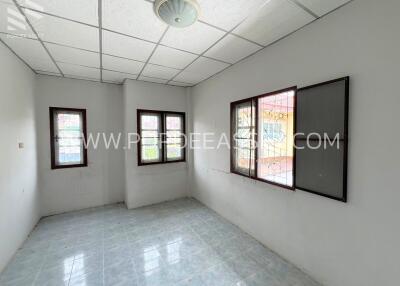 Empty bedroom with tiled floor, white walls, and windows