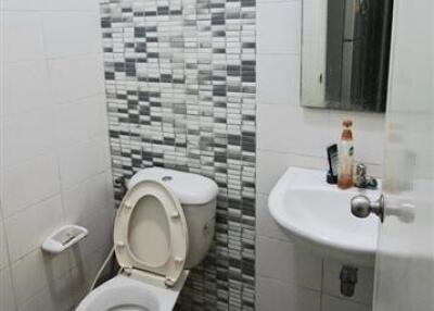 Modern bathroom with toilet, sink, and decorative wall tiles