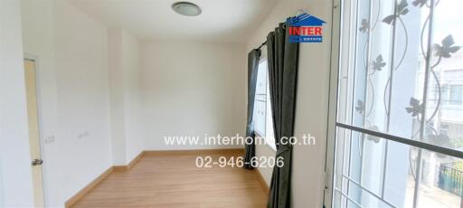 Empty bedroom with wooden floor and large window