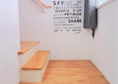 Well-lit staircase with wooden steps and motivational wall art