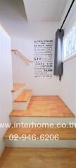 Well-lit staircase with wooden steps and motivational wall art