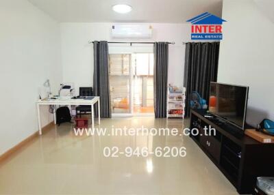 Modern living room with TV, desk, and sliding door to balcony