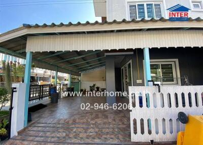 Covered outdoor area with gated entrance and house exterior