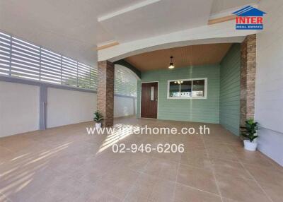 Spacious covered outdoor area with wooden ceiling and tiled floor