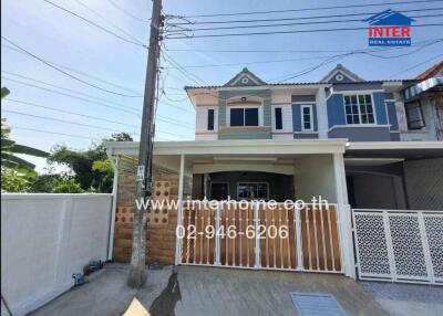 Exterior view of a two-story house with a gated driveway